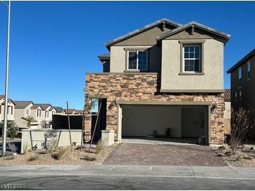 Modern two-story home with stone accents, a spacious two-car garage, and desert landscaping at 4540 Anspach St, North Las Vegas, NV 89031