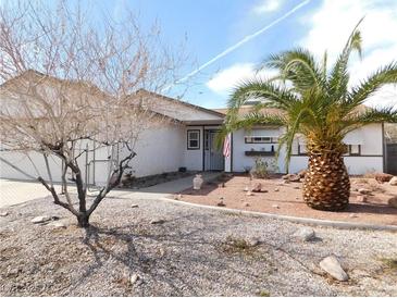 Charming single-story home with desert landscaping, including a palm tree and rock features in the front yard at 710 Strawberry Pl, Henderson, NV 89002