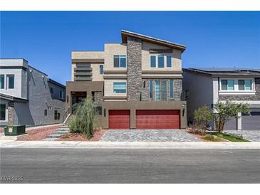 Striking three-story home with modern design elements and a red two-car garage at 7180 Grace Estate Ave, Las Vegas, NV 89113