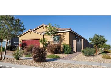 Charming single-story home with well-manicured landscaping, red garage door, and inviting curb appeal at 7910 Shimmery St, North Las Vegas, NV 89084