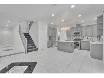 Open concept kitchen with grey cabinets, stainless steel appliances, and a beautiful island at 7917 Sally Irene Ct, Las Vegas, NV 89113