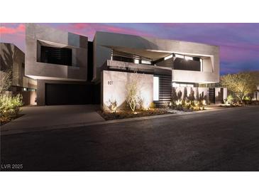 Modern home featuring a striking architectural design, dark garage door, and beautiful desert landscaping at 801 Dragons Eye Dr, Henderson, NV 89012