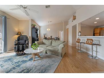 Inviting living room with open floor plan, ceiling fan, wood floors and stylish decor at 2325 Windmill Pkwy # 323, Henderson, NV 89074