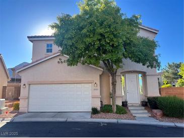 Two-story home with a two-car garage and well-maintained front yard landscaping and a mature shade tree at 3337 Autumn Veil St, Las Vegas, NV 89129