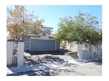 Charming two-story home featuring an attached garage and mature trees in the front yard at 3539 Japan Way, Las Vegas, NV 89115