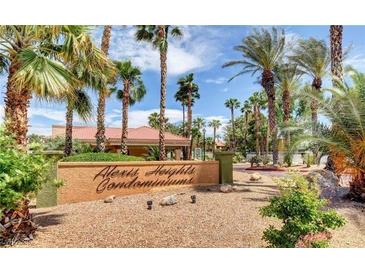 Exterior of Alexis Heights Condominiums featuring a sign and lush landscaping with palm trees at 5130 S Jones Blvd # 203, Las Vegas, NV 89118