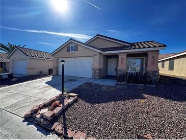 Charming single-story home featuring stone accents, a two-car garage, and a neatly landscaped front yard at 5513 Oakwood Ridge St, Las Vegas, NV 89130