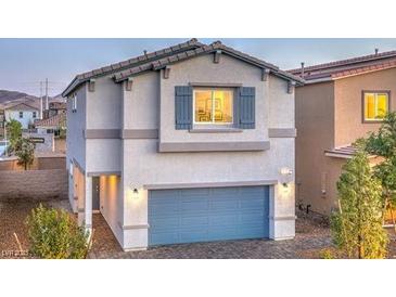 Charming two-story home featuring a blue garage door and well-maintained landscaping at 9938 Ullom Dr # Lot 6, Las Vegas, NV 89141