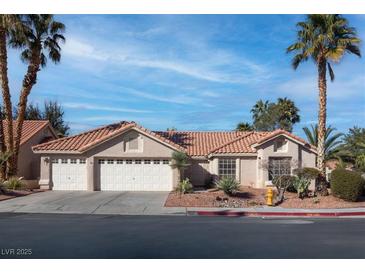 Charming single-story home featuring a three-car garage and a beautifully landscaped front yard with mature palm trees at 1270 Del Lilly Ln, Las Vegas, NV 89123