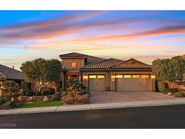 Charming two-story home featuring a stone facade, three-car garage, and well-manicured landscaping at sunset at 2869 Josephine Dr, Henderson, NV 89044