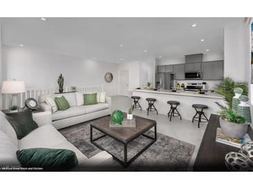 Open-concept living room and kitchen with modern finishes, stainless appliances and an inviting breakfast bar at 5729 Crenellated St # Lot 68, Las Vegas, NV 89148