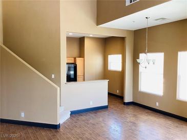 Bright living room with hardwood floors, large windows, and a modern chandelier at 8777 W Maule Ave # 2167, Las Vegas, NV 89148