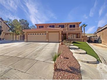 Two-story home with a large driveway, desert landscaping, and a balcony at 9885 Ramhorn Canyon St, Las Vegas, NV 89183