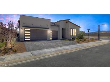 Modern home featuring a three-car garage and neatly landscaped front yard at 10065 Auburn Rose Ave, Las Vegas, NV 89143