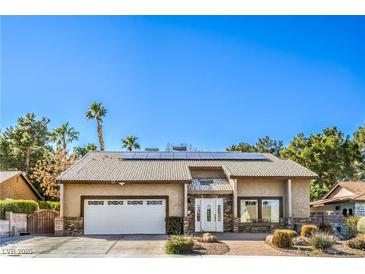 Charming single-story home with a two car garage, desert landscaping, and solar panels on the roof at 2233 Marlboro Dr, Henderson, NV 89014