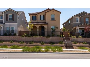Charming two-story home featuring stucco exterior, tile roof, and landscaped front yard with wrought iron fence at 2665 Piroli St, Henderson, NV 89044
