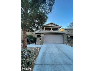 Two-story home with a two-car garage, stone accents, and manicured landscaping at 5413 Bristol Bend Ct, Las Vegas, NV 89135