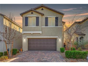Charming two-story home with a brick driveway and attached two-car garage and manicured landscaping at 6221 Desert Orchid Way, Las Vegas, NV 89141