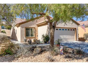 Charming single story home with stucco siding, desert landscaping, and a two car garage at 7669 Fieldfare Dr, North Las Vegas, NV 89084