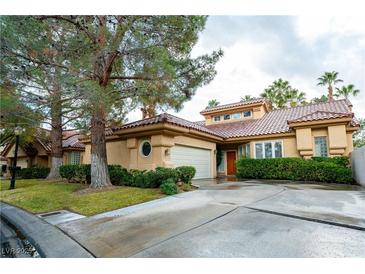 Inviting single-story home featuring a red tile roof, mature landscaping, and a convenient attached two-car garage at 8169 Pinnacle Peak Ave, Las Vegas, NV 89113