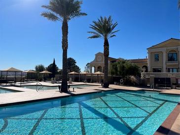 Resort-style pool area featuring multiple pools, lounging areas, and palm trees against a bright blue sky at 21 Via Visione # 201, Henderson, NV 89011