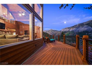 Inviting deck with mountain views, outdoor seating, wood floors, and wood and steel railings at 4888 Snow White Rd, Las Vegas, NV 89124