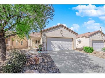 Charming single-story home with a well-maintained front yard and a two-car garage at 7633 Lily Trotter St, North Las Vegas, NV 89084