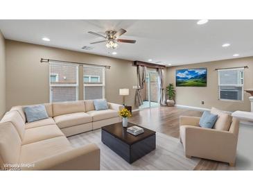 Bright living room features a neutral color palette, hardwood floors, and a comfortable sectional couch at 8683 Bella Jewel Ave, Las Vegas, NV 89178