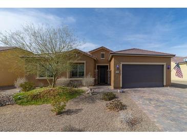 Inviting single-story home with desert landscaping, charming curb appeal, and a brick-paved driveway at 967 Buggy Whip Ct, Mesquite, NV 89034