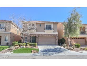 Two story home with a two car garage, stone accents and xeriscaped front yard at 9870 Giant Steps Ct, Las Vegas, NV 89141