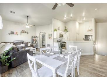 Bright open-concept living and dining area features wood floors, ceiling fans, and neutral decor at 1099 Sheer Paradise Ln # 1, Henderson, NV 89002