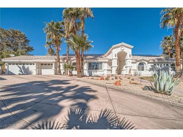 Spacious single-story home featuring a white facade, tile roof, desert landscaping, and a three-car garage at 1831 Rosemere Ct, Las Vegas, NV 89117