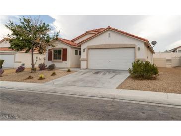 Charming single-story home featuring a red tile roof, neutral stucco, and a two-car garage at 629 Bright Lights Ave, North Las Vegas, NV 89031
