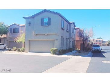 Two-story home with a two-car garage and manicured landscaping, offering curb appeal and convenience at 8957 Rufina St, Las Vegas, NV 89148