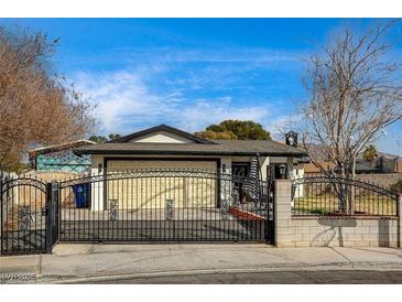 Charming single-story home featuring an ornate black iron gate for added security and curb appeal at 321 Agora Way, Las Vegas, NV 89110