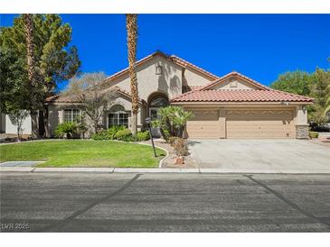 Charming single-story home with a well-manicured lawn and a three-car garage at 9725 La Cienega St, Las Vegas, NV 89183