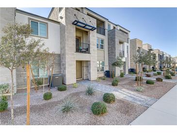 Modern townhome featuring low maintenance front yard, neutral stucco, concrete accents, and metal awnings at 1103 Tektite Ave, Henderson, NV 89011