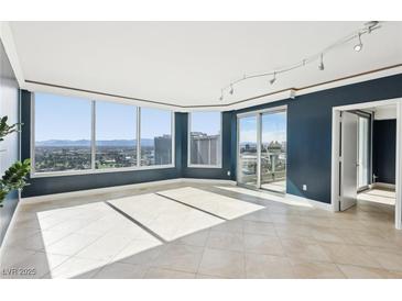 Bright living room featuring tile flooring, floor-to-ceiling windows, and a sliding door to balcony with city views at 322 Karen Ave # 2501, Las Vegas, NV 89109