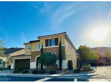 Beautiful two-story stucco home with a well-manicured lawn, dark shutters, and a two-car garage at 945 Pomander Point Pl, Henderson, NV 89012