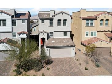 Charming two-story home featuring a red door, two-car garage, and a well-manicured front yard at 120 Campbelltown Ave, Henderson, NV 89015