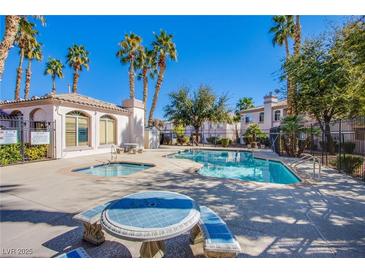 Community pool and spa area, with a picnic table, palm trees, and a secure gated fence at 4555 E Sahara Ave # 132, Las Vegas, NV 89104