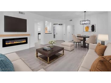 Bright living room boasts an electric fireplace, modern lighting, and an adjacent dining area at 5155 W Tropicana Ave # 1052, Las Vegas, NV 89103