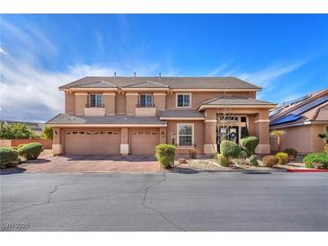 Two-story home showcasing a three-car garage, manicured landscaping, and a welcoming entrance at 5868 Revital Ct, Las Vegas, NV 89131