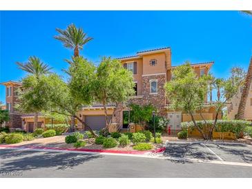 Charming townhome showcases lush landscaping, desert plants, and a stone-accented facade at 65 Luce Del Sole # 1, Henderson, NV 89011