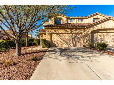 Charming two-story home with a tile roof, a two-car garage, mature trees, and landscaped front yard at 3098 Quail Crest Ave, Henderson, NV 89052