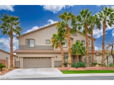 Charming two-story home with a two-car garage, complemented by manicured landscaping and stately palm trees at 404 Via Sonador, Henderson, NV 89012