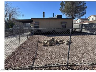 View of the gravel backyard area enclosed by chain link fence at 424 Jefferson Blvd, Henderson, NV 89011