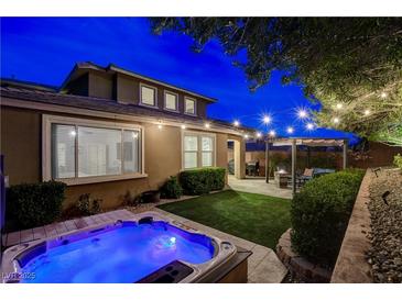 Inviting backyard with a jacuzzi, patio, pergola, string lights, and well-manicured landscaping perfect for relaxation at 5741 Shadow Bend Dr, Las Vegas, NV 89135