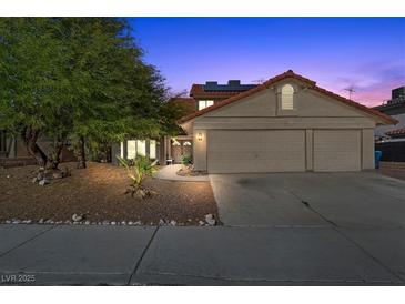 Inviting two-story home featuring a red tile roof, well-maintained landscaping, and an attached two-car garage at 8912 Dio Guardi Dr, Las Vegas, NV 89117
