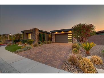 Beautiful single-story home with stone accents, brick driveway, and well-manicured landscaping at 15 Reflection Bay Dr, Henderson, NV 89011